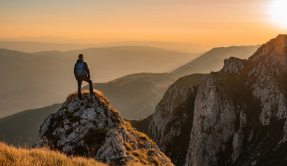 Mann steht auf einem Berg und blickt in die Weite