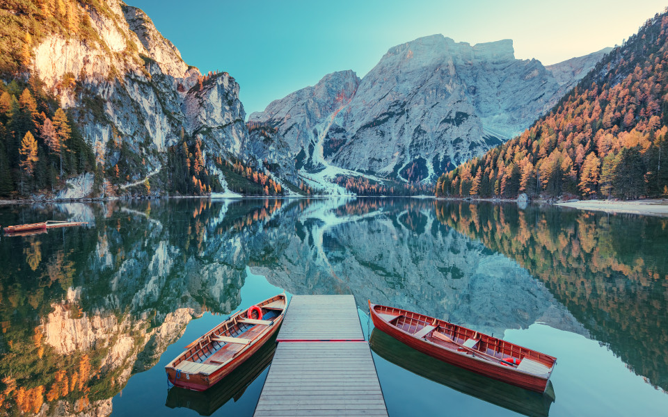 Blick auf den Lago di Braies mit zwei rooten Booten im Vordergrund